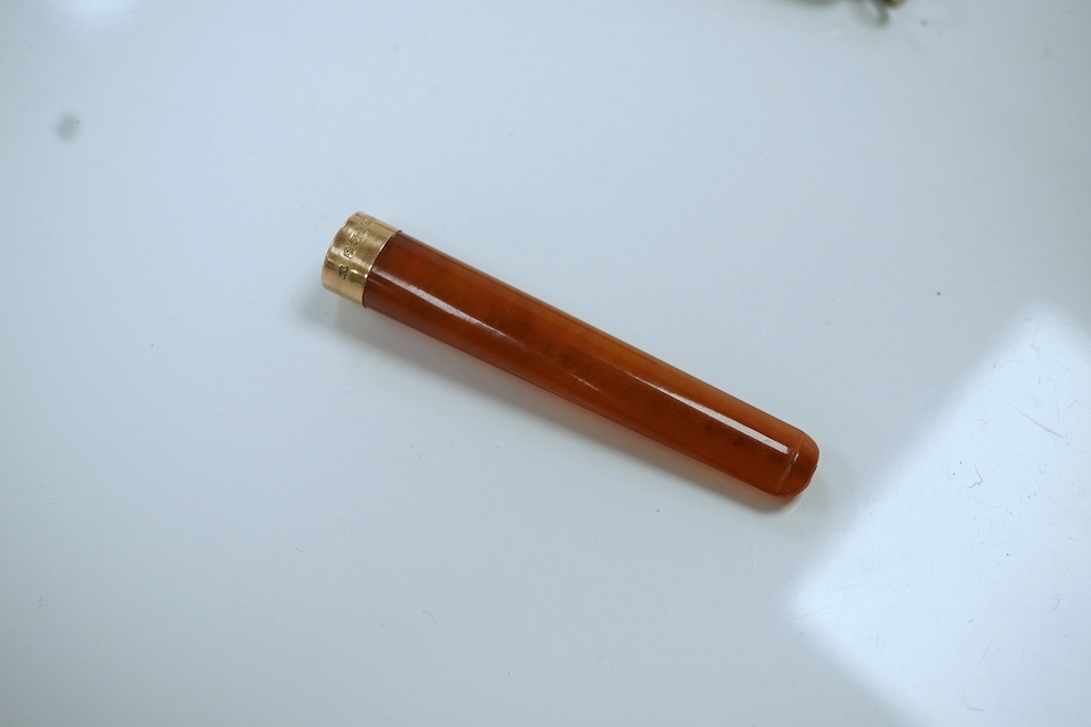 A 9ct gold mounted amber cigarette holder, 78mm, in a silver case. Condition - fair